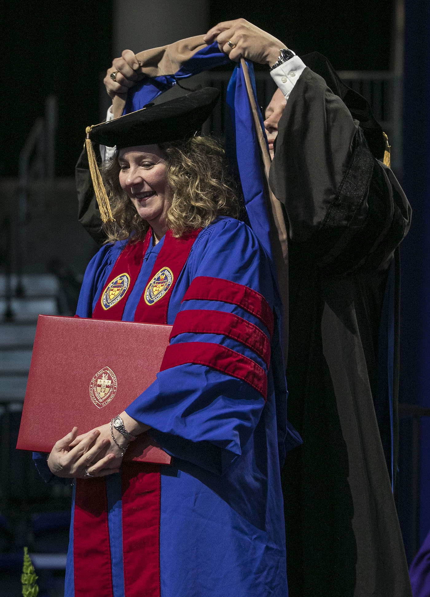 Driehaus College of Business doctoral graduate Tammy Higgins receives her hood during the DePaul University commencement ceremony